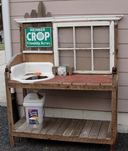 Potting bench made from wood pallets, a window, and an old sink